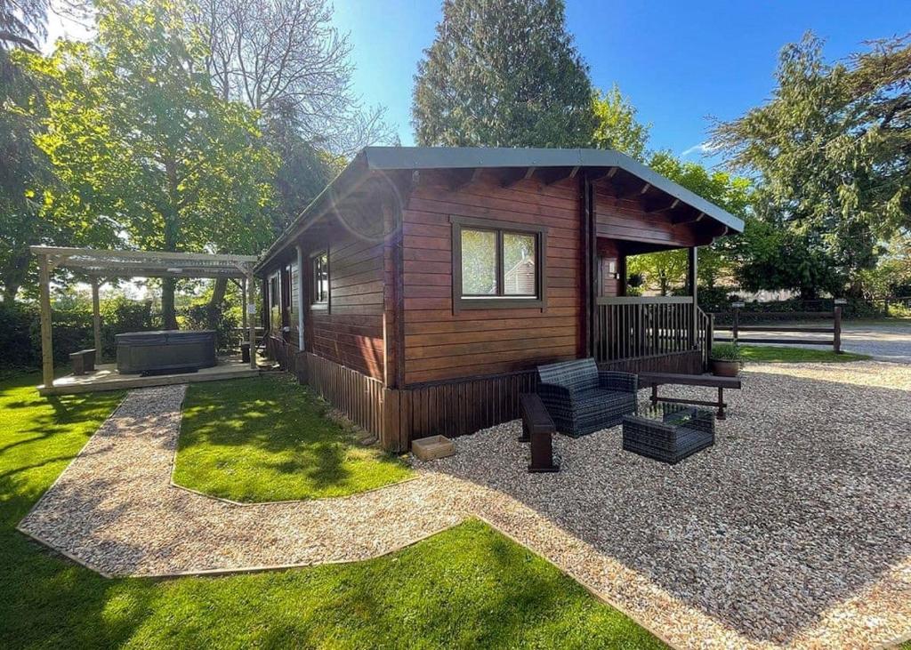 um pequeno chalé de madeira com um gazebo em Oathill Farm Lodges em Winsham