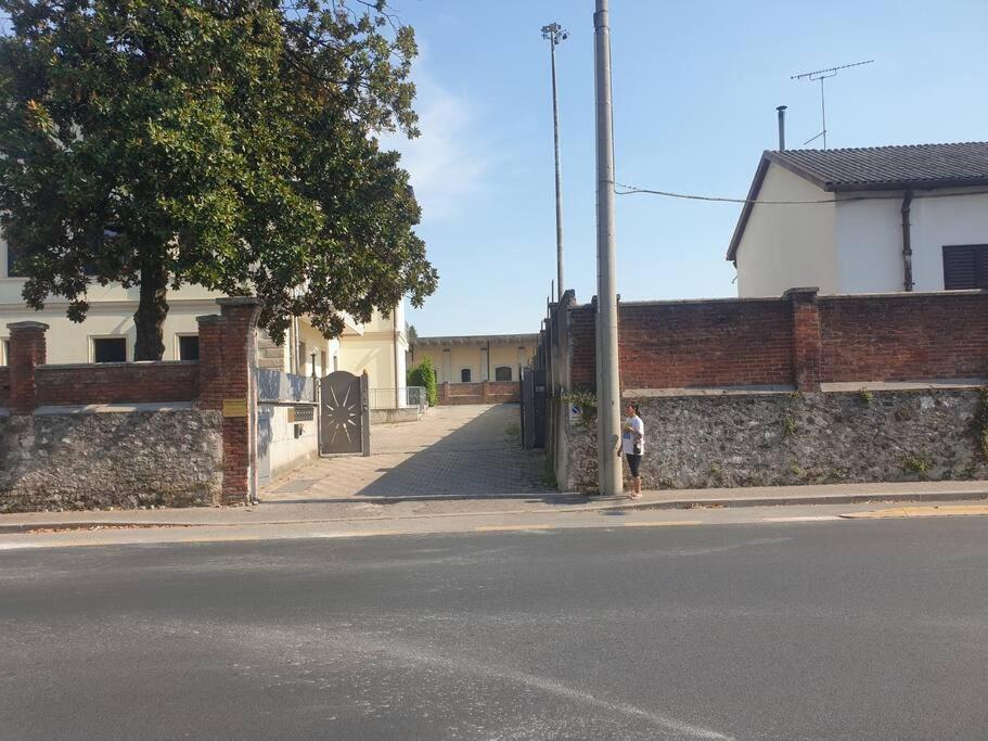 a person standing next to a brick wall on a street at [PIAZZA GARIBALDI] ELEGANTI SUITE CON SAUNA in Udine