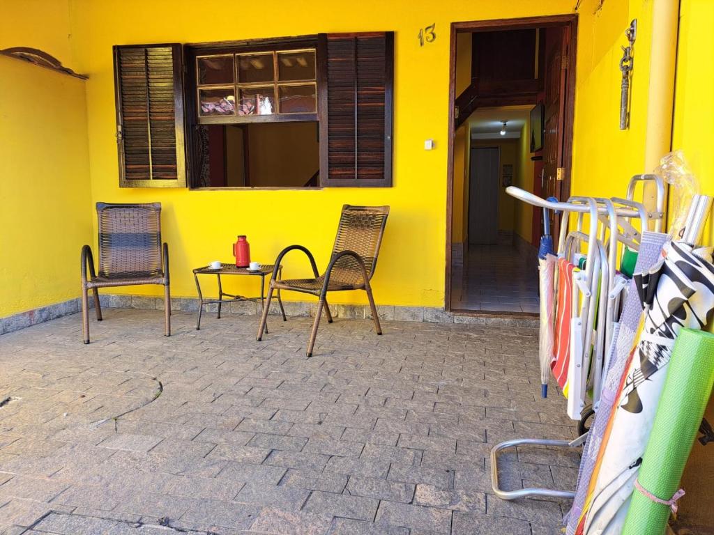a yellow building with two chairs and a table at Casa Amarela in Paraty