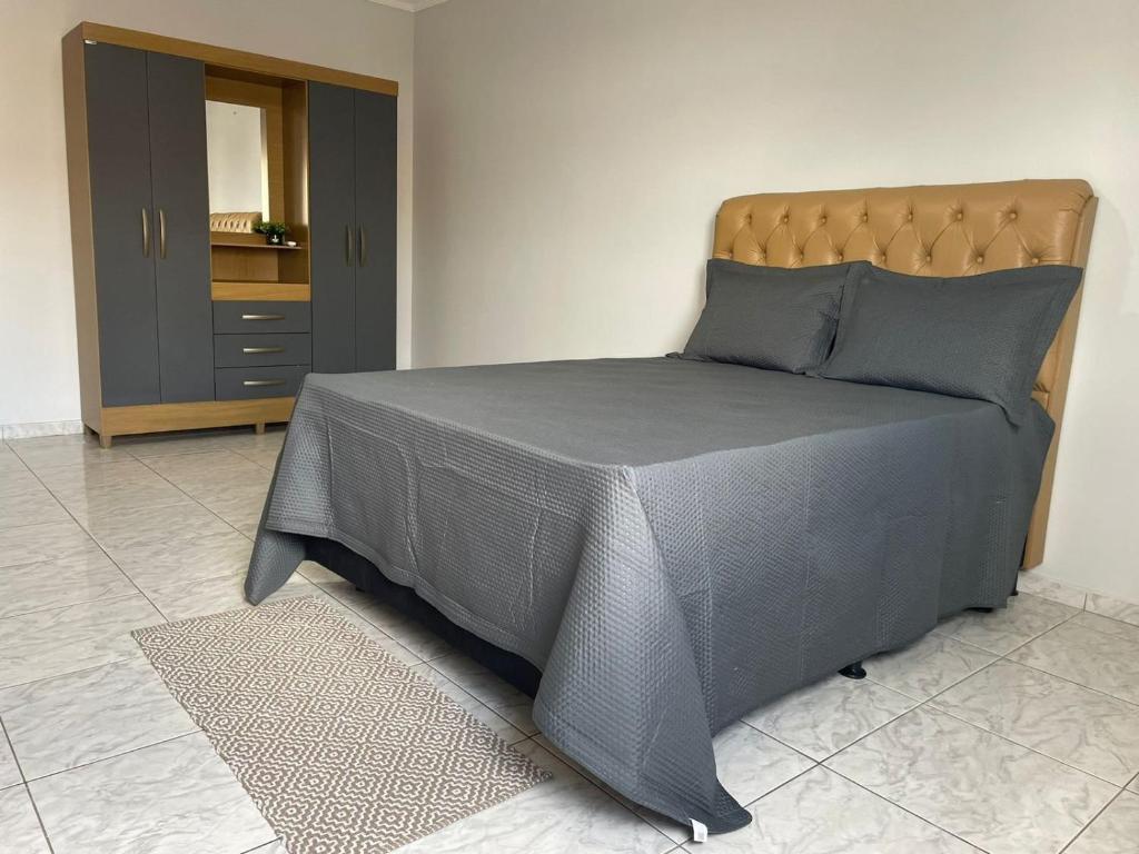 um quarto com uma cama com um edredão cinzento em Apartamento amplo, confortável e equipado - Apt 101 em Anápolis
