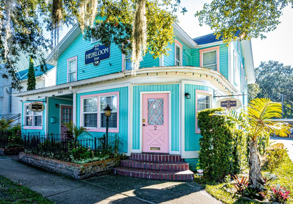 una casa azul con una puerta rosa en The Heirloom Inn, en Mount Dora