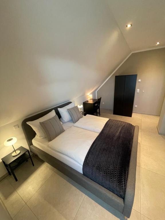 1 dormitorio con 1 cama blanca grande con manta negra en Privatzimmer Steinmetz in Reken, en Reken