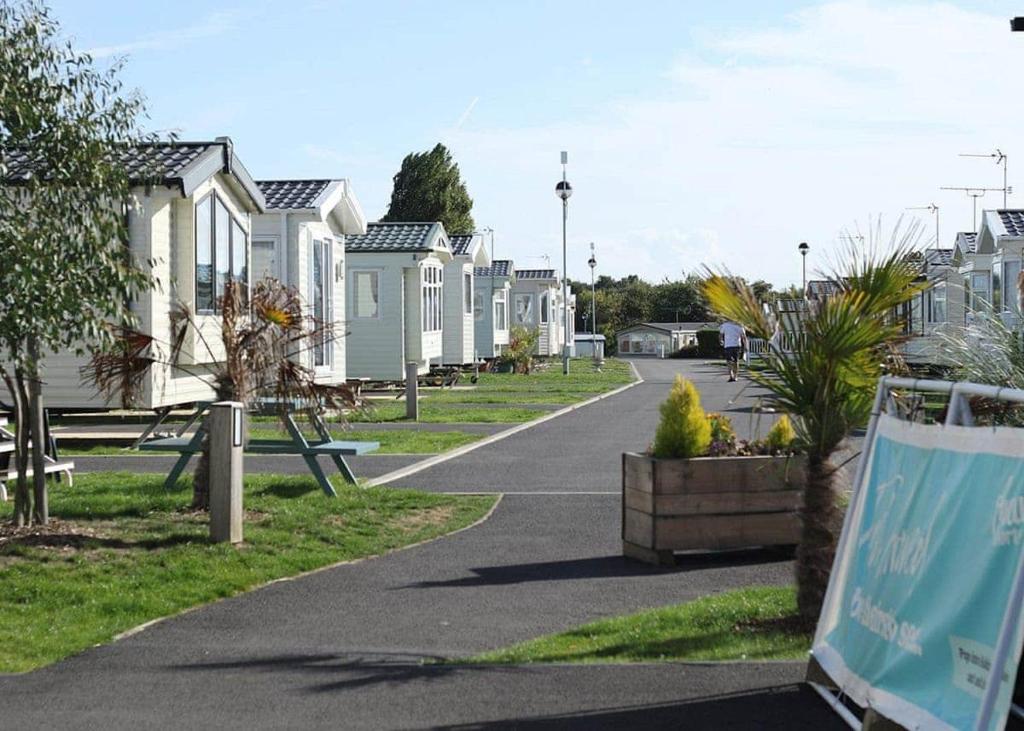 a street with a row of white houses at Mersea Island Holiday Park in East Mersea