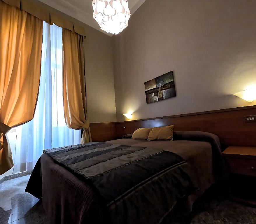 ein Schlafzimmer mit einem Bett und einem großen Fenster in der Unterkunft Hotel Cervia in Rom
