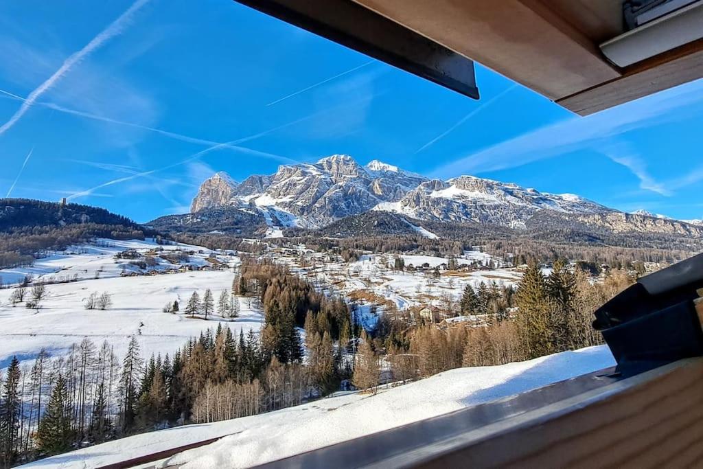 a view of a snow covered mountain from a window at Mansardina Mery Cortina in Cojana