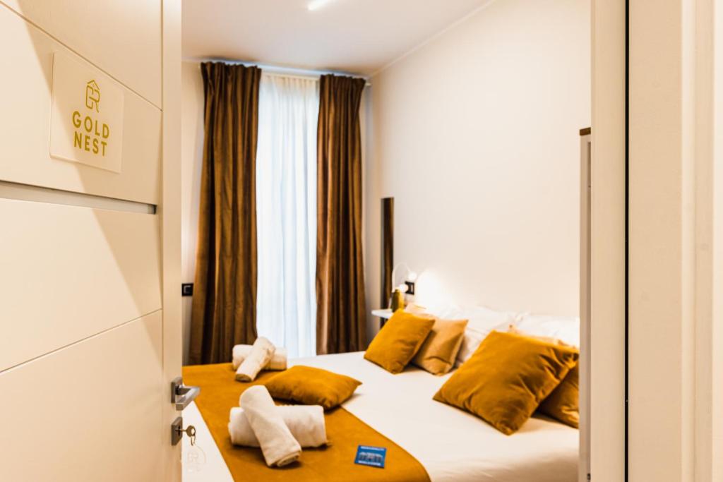 a hotel room with a bed with yellow pillows at Gegix's Rooms Milano in Milan