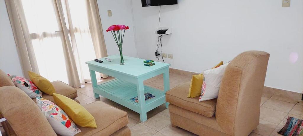 una sala de estar con una mesa con un jarrón de flores. en Dpto. 2 dormitorios totalmente equipado en Salta
