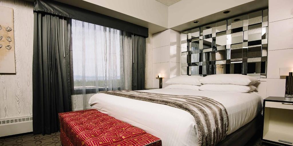 a bedroom with a large white bed and a window at Harrah's Lake Tahoe Hotel & Casino in Stateline