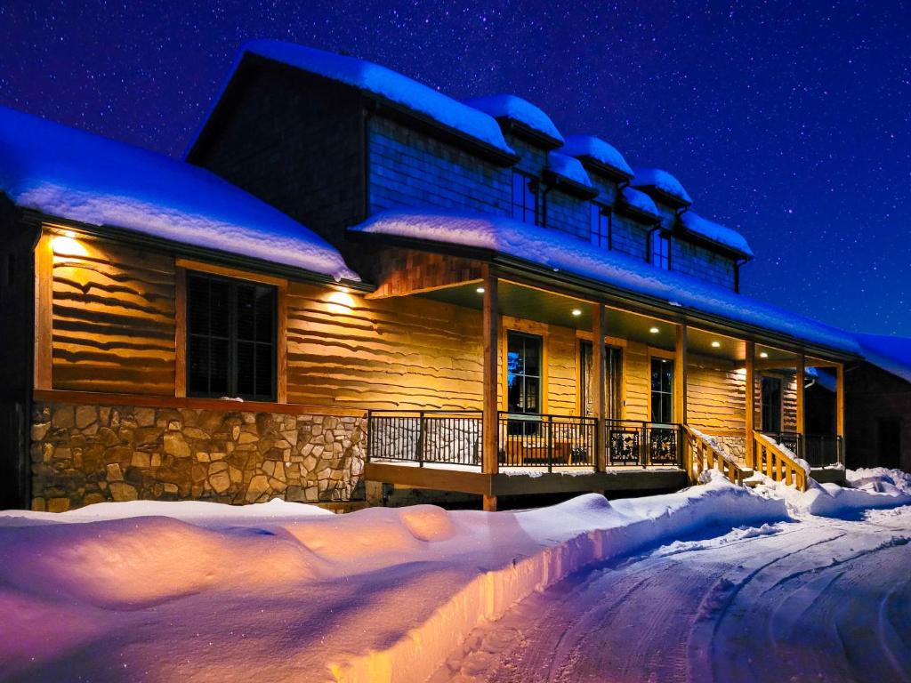 a log cabin in the snow at night at East Zion Trails Retreat-Hot tub, Resort Amenities, Exceptional in Orderville