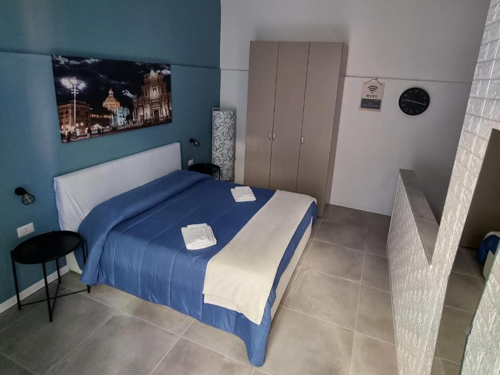 una camera con un letto blu e bianco e una scala di Il vicolo home a Catania