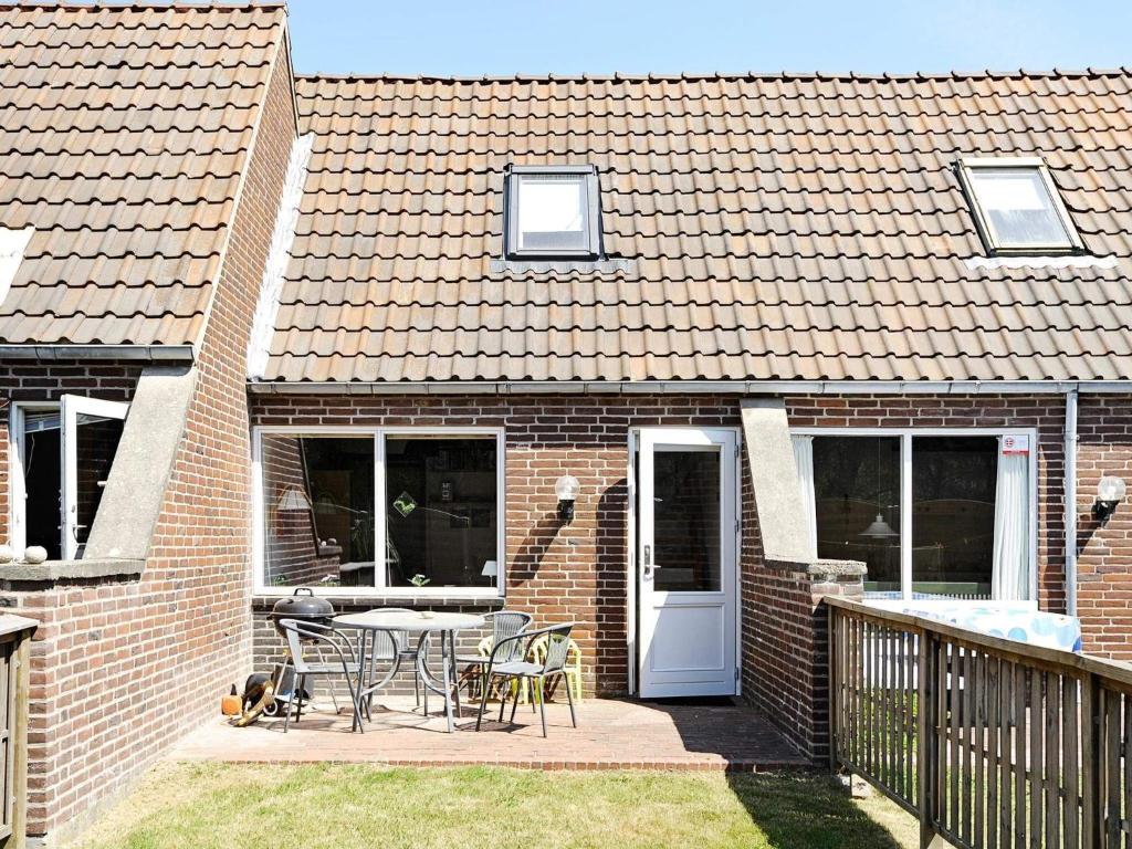 a brick house with a patio with a table and chairs at Holiday home Rømø CXXV in Rømø Kirkeby