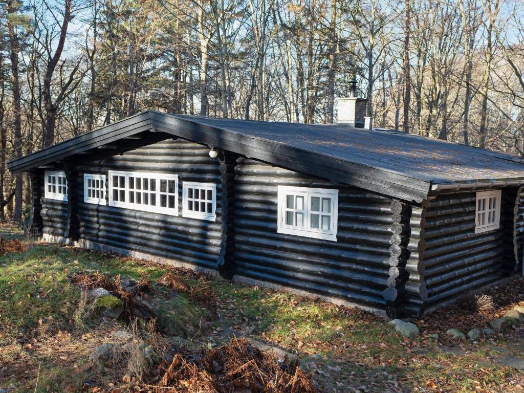 eine Blockhütte mit drei Fenstern an der Seite in der Unterkunft 4 person holiday home in Frederiksværk-By Traum in Frederiksværk