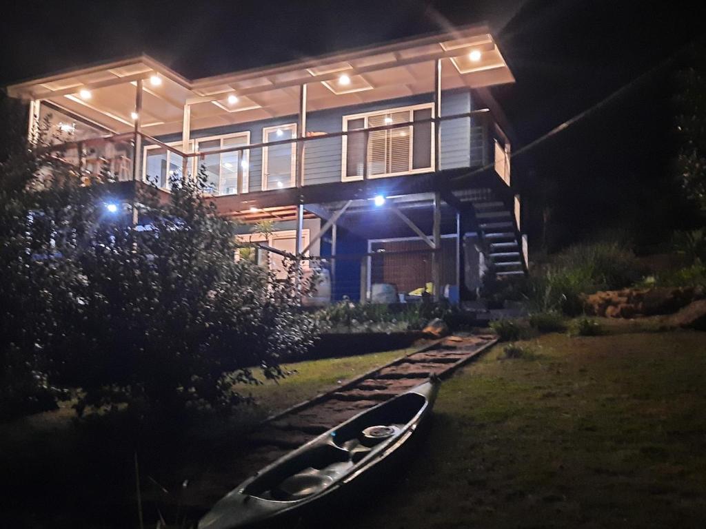 a boat sitting in front of a house at night at Seafarers Landing Bar Point NSW in Bar Point