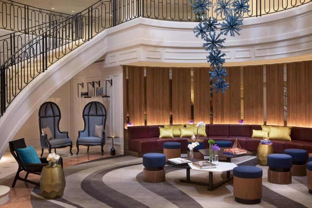 a lobby with couches and chairs and a staircase at Renaissance Paris La Defense Hotel in Puteaux