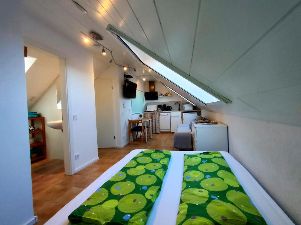 a room with a bed with a green blanket on it at Auszeit im Grünen - Ferienwohnung in Hünxe in Hünxe