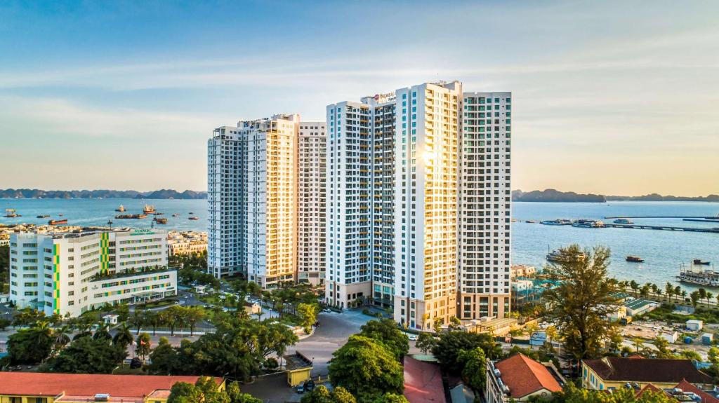 Best Western Premier Sapphire Ha Long في ها لونغ: منظر هوائي للمباني الطويلة بجانب الماء