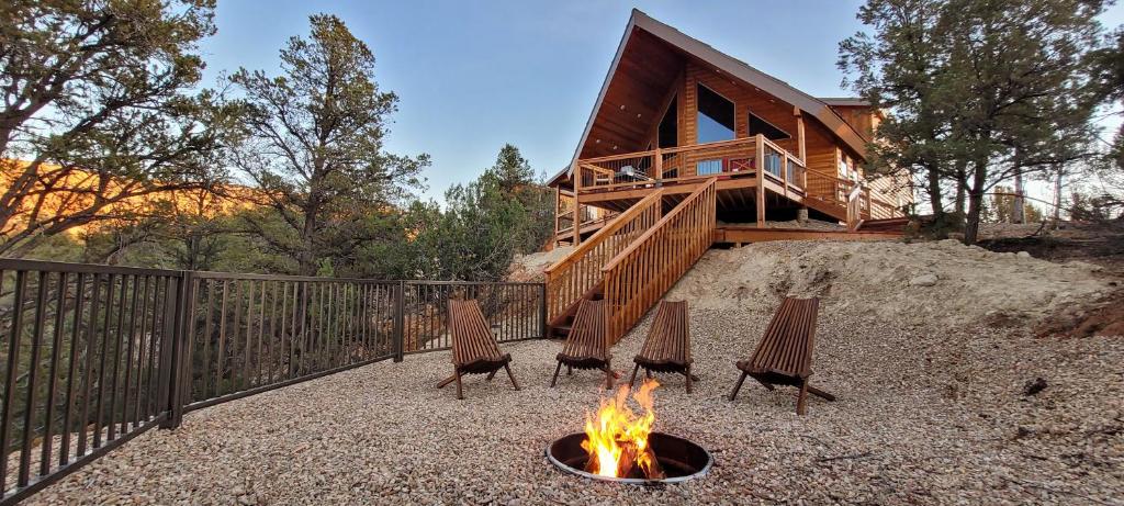 a fire pit with four chairs in front of a house at Cliff's Edge. New Build, Breathtaking Views, Luxury Stay Near Zion in Orderville