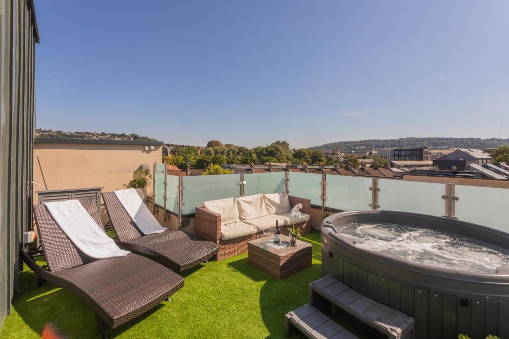 a patio with chairs and a hot tub on a balcony at Henge House, Penthouse Apartment in Bath