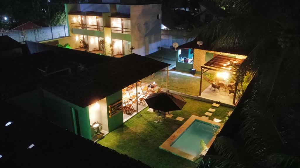 an overhead view of a house at night with a swimming pool at Arraia Suítes Pousada in Pipa