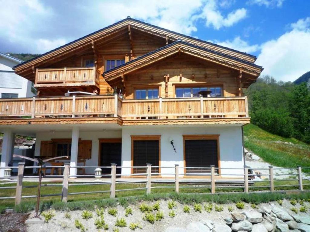 a large wooden house with a balcony on top at Chalet Mund in Mund