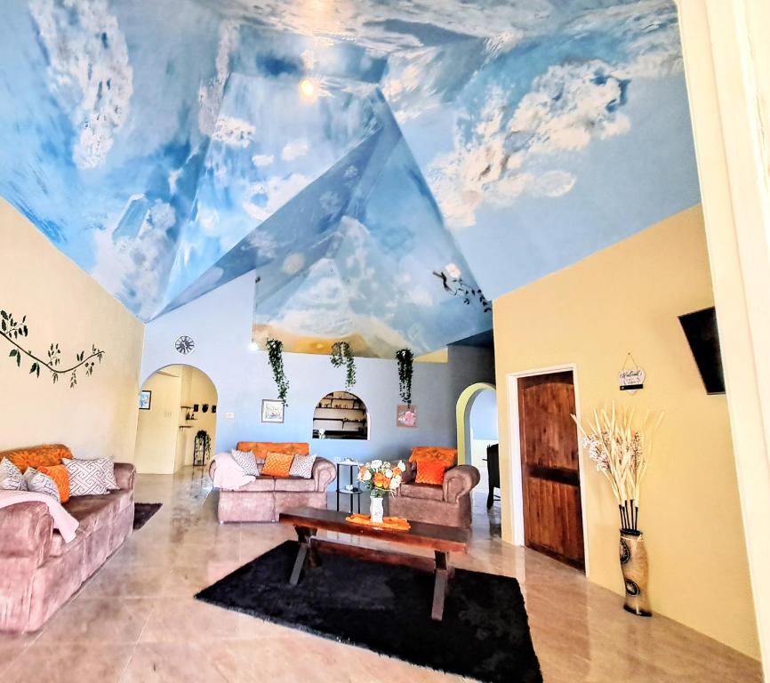 a living room with a ceiling mural of clouds at Southaven Oasis 
