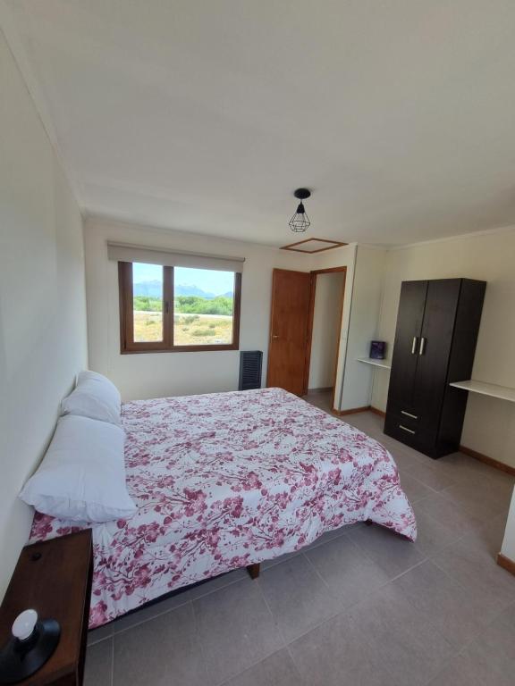 Un dormitorio con una cama grande y una ventana en Calahue Apart en Trevelín