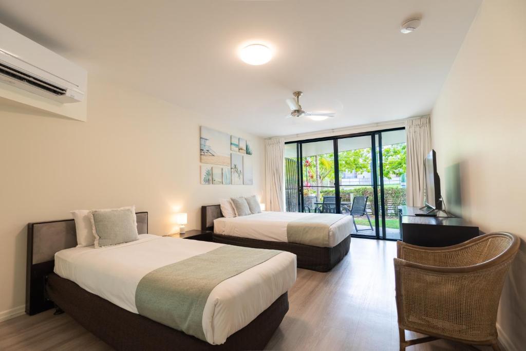 a hotel room with two beds and a tv at Agnes Water Beach Club in Agnes Water