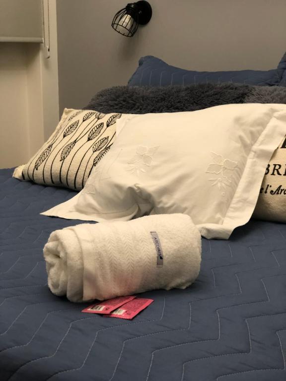 toalla blanca sobre una cama con almohadas en Departamento Recoleta I en Buenos Aires