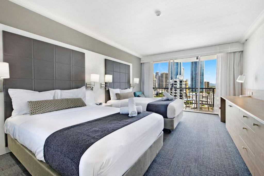 a hotel room with two beds and a large window at Deluxe Twin Studio in Surfers Paradise in Gold Coast