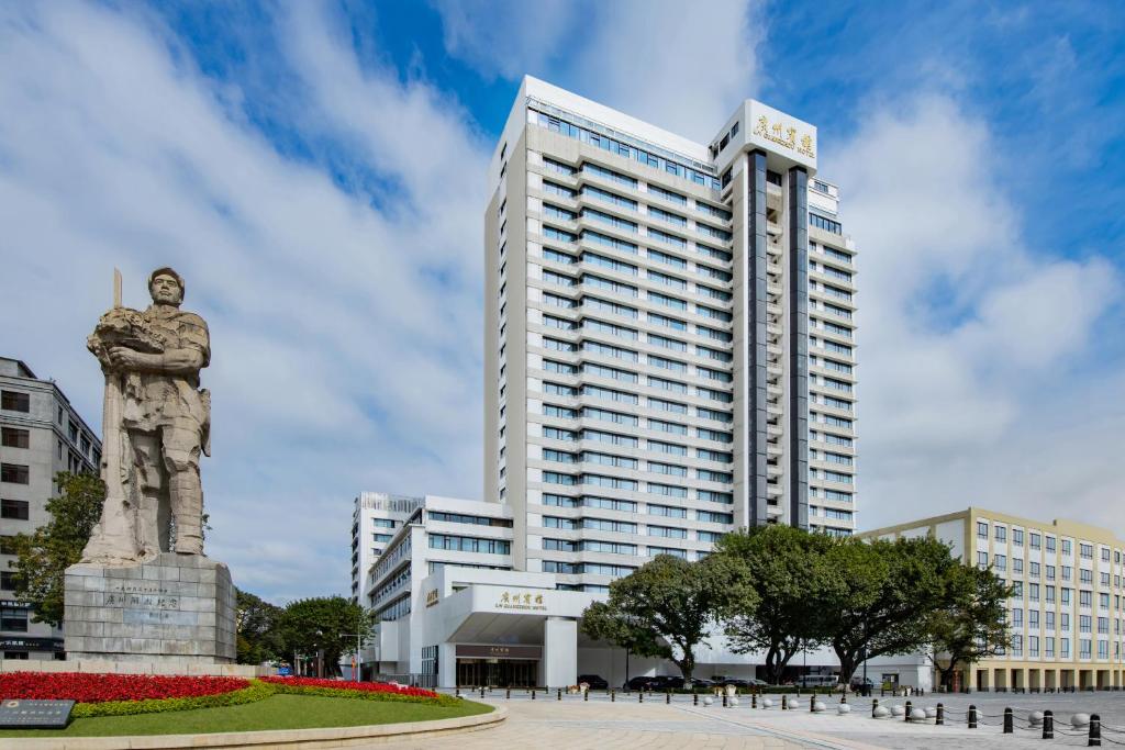 a statue in front of a tall building at Guangzhou Hotel - Haizhu square metro station & close to Beijing road in Guangzhou