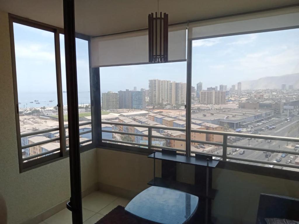 a room with a balcony with a view of a city at Amoblados MyK Portal Heroes, Mall Plaza in Iquique