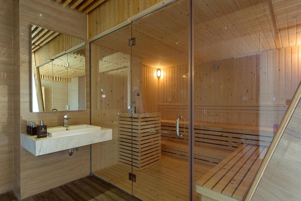 a wooden bathroom with a sink and a tub at Boton Blue Hotel & Spa in Nha Trang