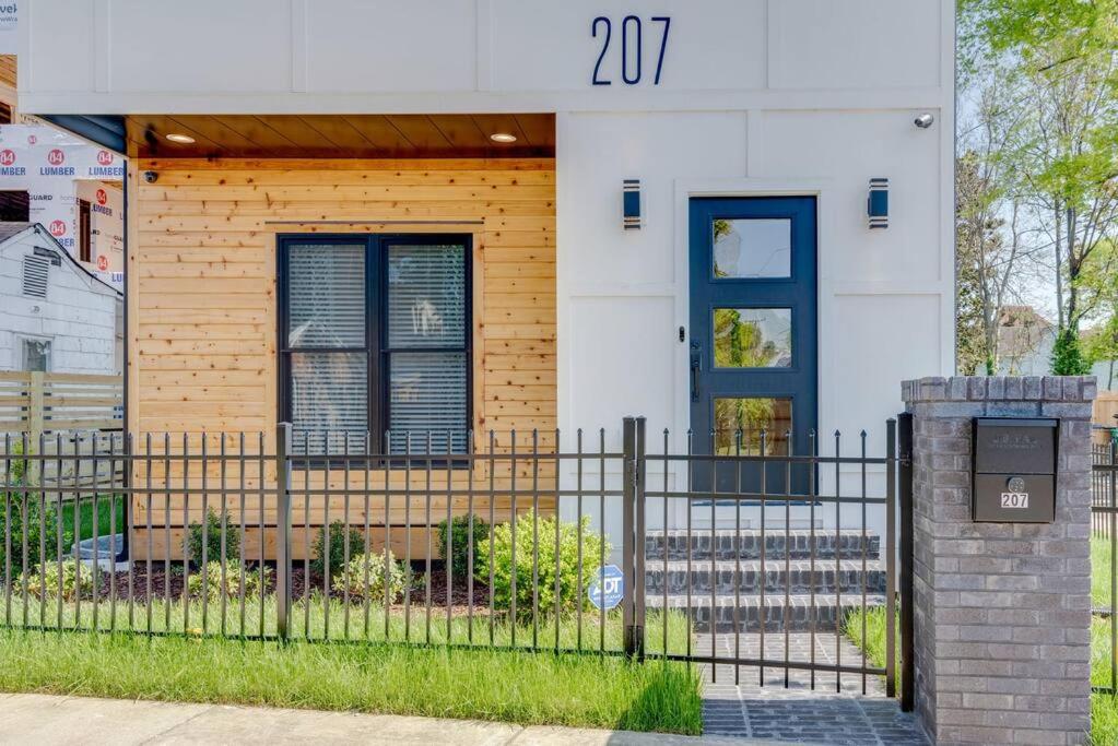 a house with a blue door and a fence at Luxury Downtown Nash/Roofdeck/11 Beds in Nashville