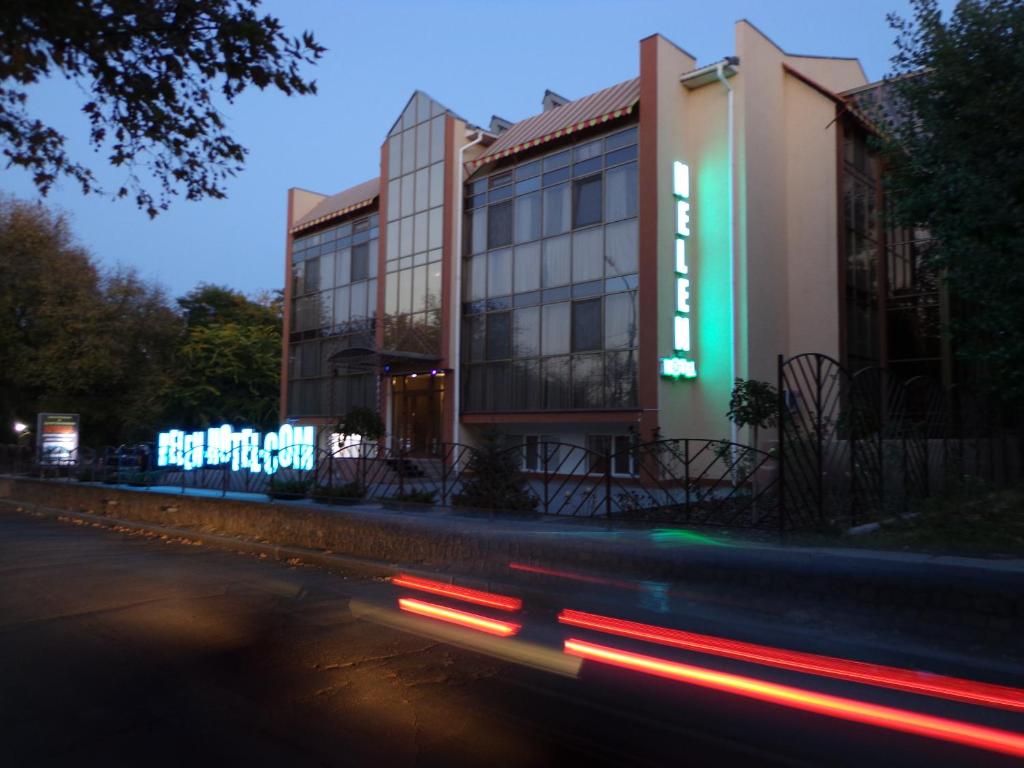 a building with neon signs on the side of a street at Helen Hotel in Mykolaiv