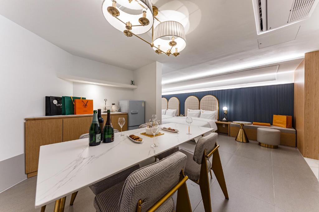 une salle à manger avec une table et des chaises blanches dans l'établissement Brown Dot Hotel Cheonan Buldang, à Cheonan