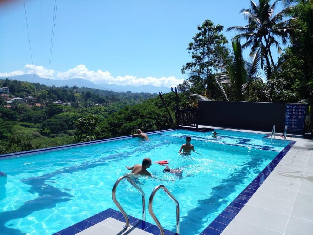 un grupo de personas nadando en una piscina en OYO 278 Hotel Rivelka, en Kundasale