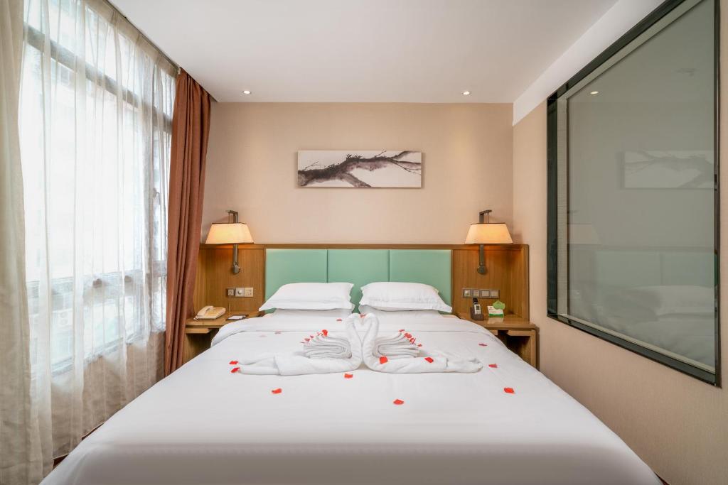Postel nebo postele na pokoji v ubytování Guangzhou Boyi Hotel