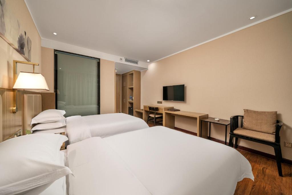 Postel nebo postele na pokoji v ubytování Guangzhou Boyi Hotel