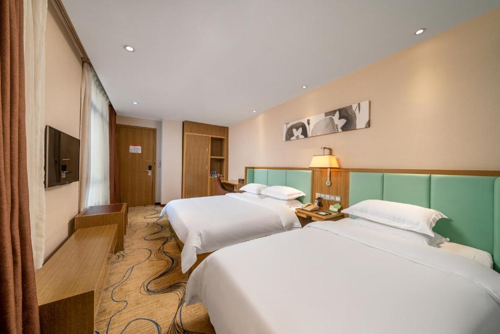 Postel nebo postele na pokoji v ubytování Guangzhou Boyi Hotel