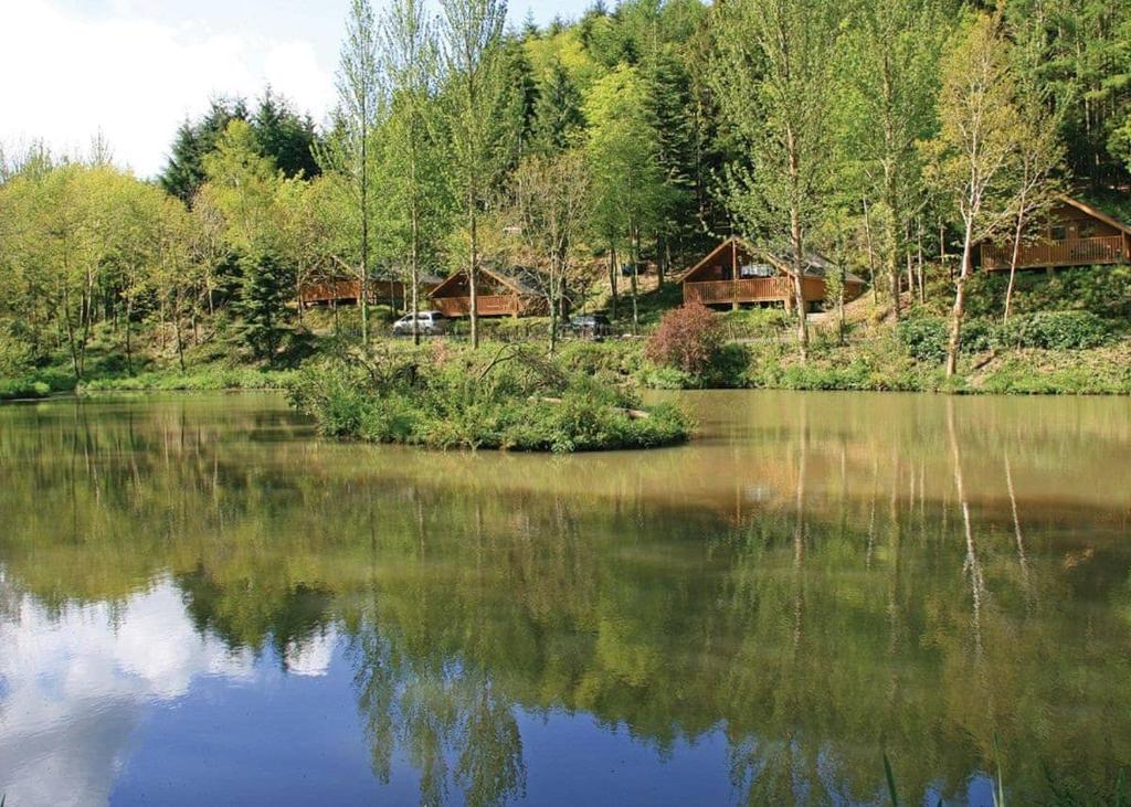 a view of a lake with houses in the background at Bulworthy Forest Lodges in Instow