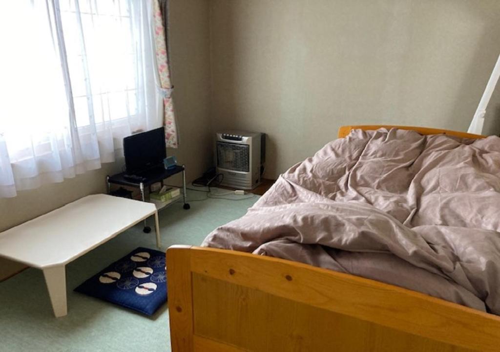 a bedroom with a bed and a desk and a television at Otaru - House - Vacation STAY 87614 in Otaru