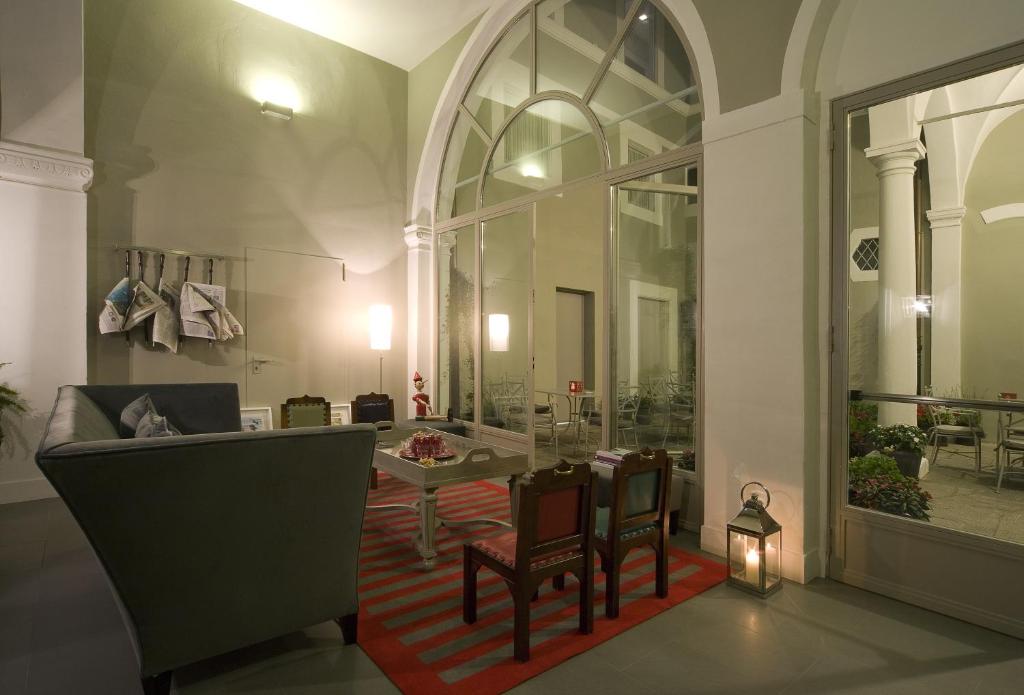 uma sala de estar com uma mesa e cadeiras num quarto em Hotel Rosso23 - WTB Hotels em Florença