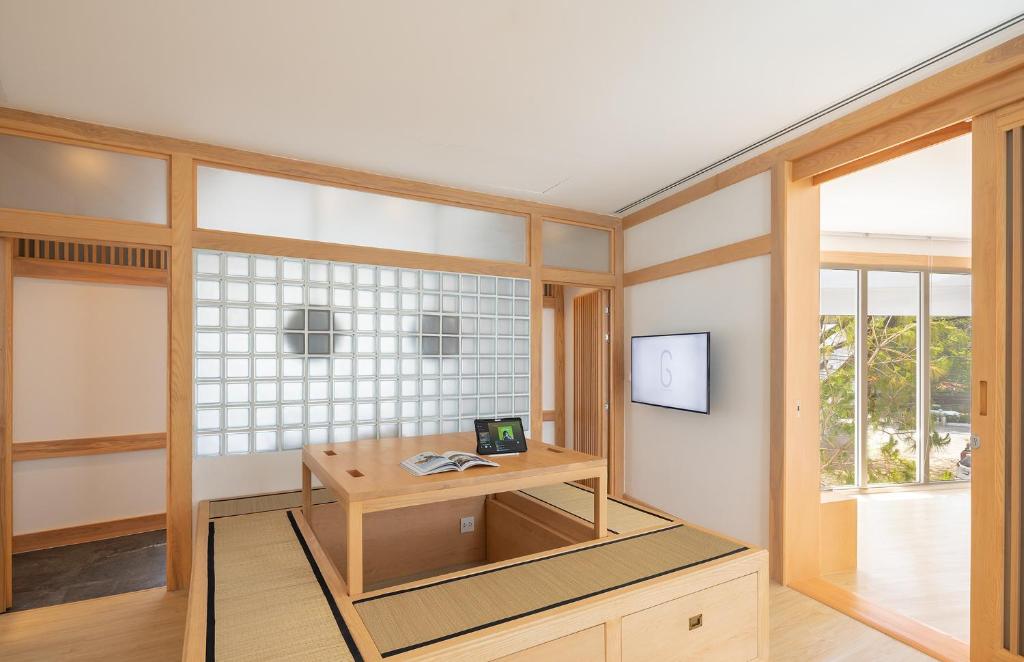 A Japanese-inspired work area with a low wooden desk beside a bright window.