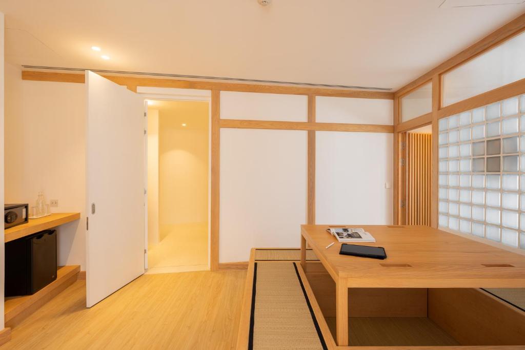 A low wooden work table faces a glass-block partition beside the room entrance.