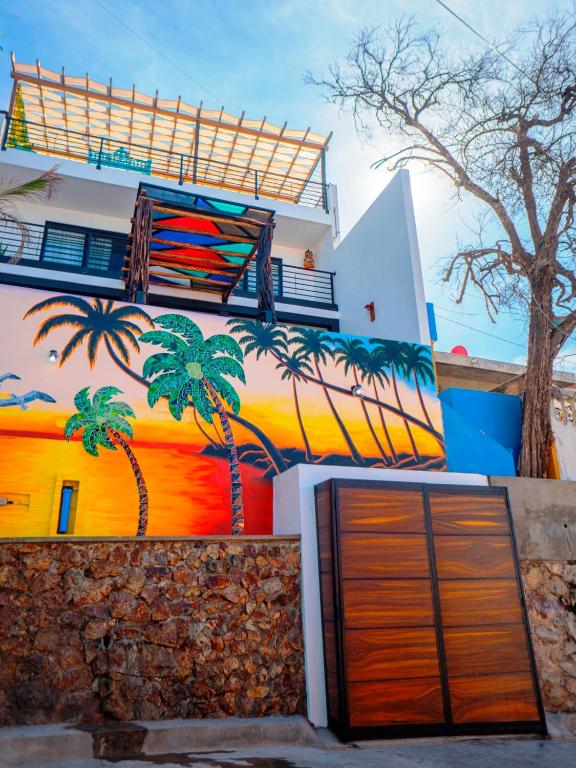 un edificio con una pintura de palmeras. en Rincon de Liz, en Mazatlán