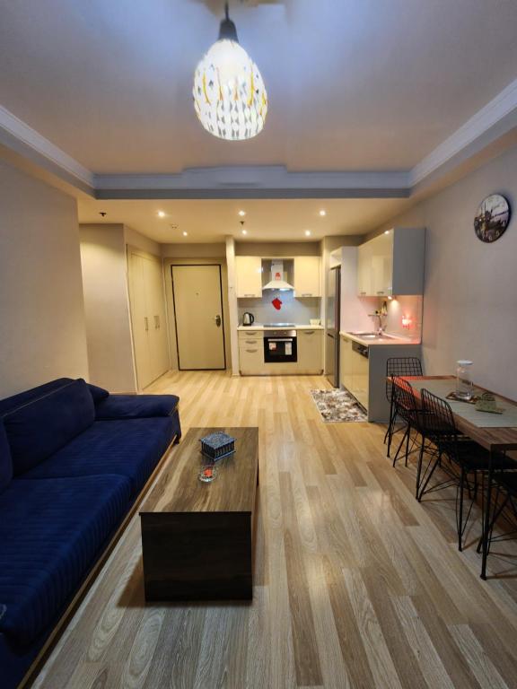 Luxury apartment in Istanbul في إسطنبول: غرفة معيشة مع أريكة زرقاء وطاولة