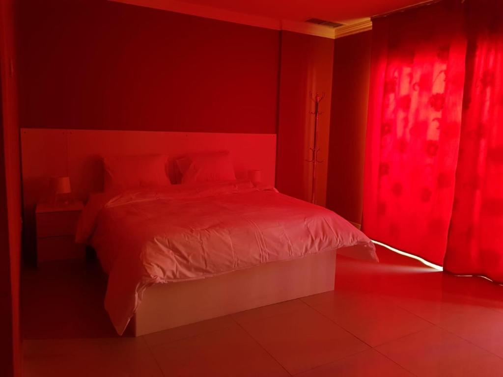 a red bedroom with a bed and a red light at شقق رهف السالميه in Kuwait