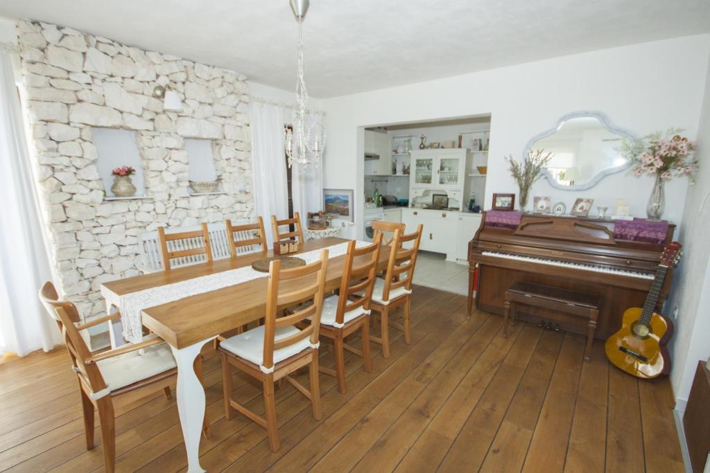 a dining room with a table and a piano at Drnis Dream Apartment in Drniš