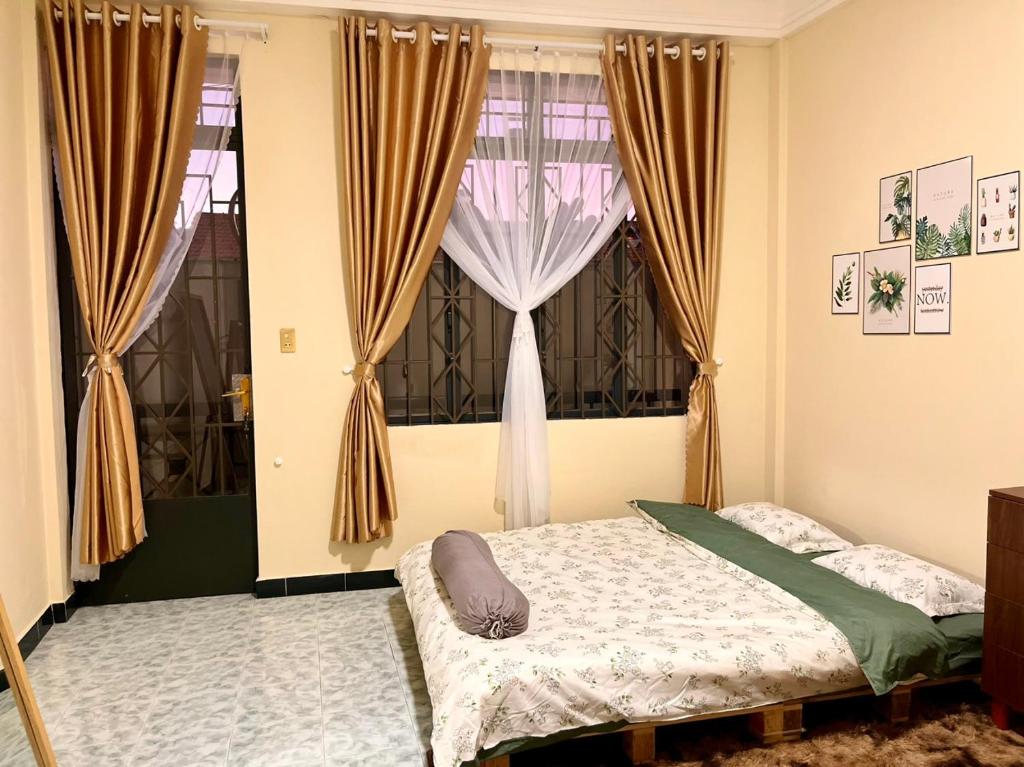 um quarto com uma cama e uma janela com cortinas em Viet Hoang's House em Da Lat