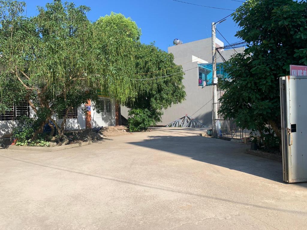 une rue vide devant un bâtiment avec un arbre dans l'établissement Nhà nghỉ Chiều Tím, à Lạng Sơn